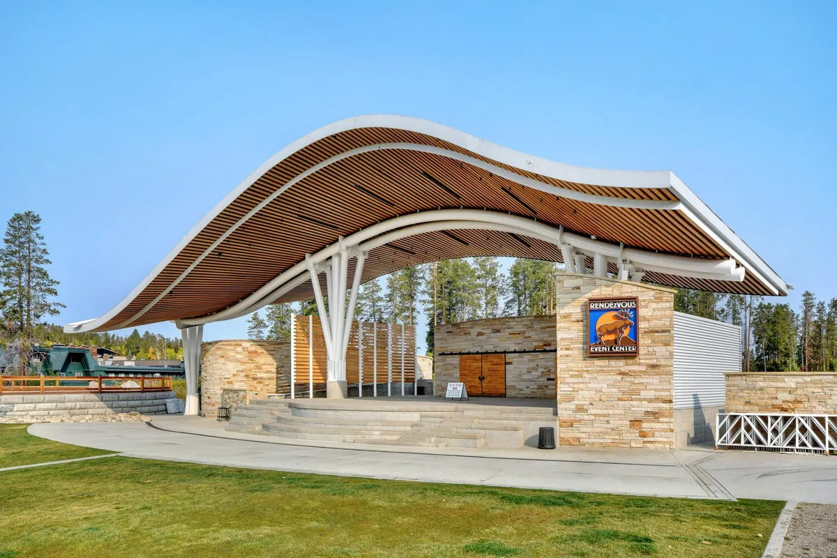 An exterior shot capturing the curved roof structure and stone facade of an outdoor stage, with steps leading up to the area. The open-air setting is ideal for concerts, community festivals, and events, reflecting the vibrancy and communal spirit of downtown Winter Park.